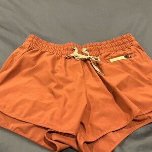 Vuori Women's Athletic Shorts in Rust Orange